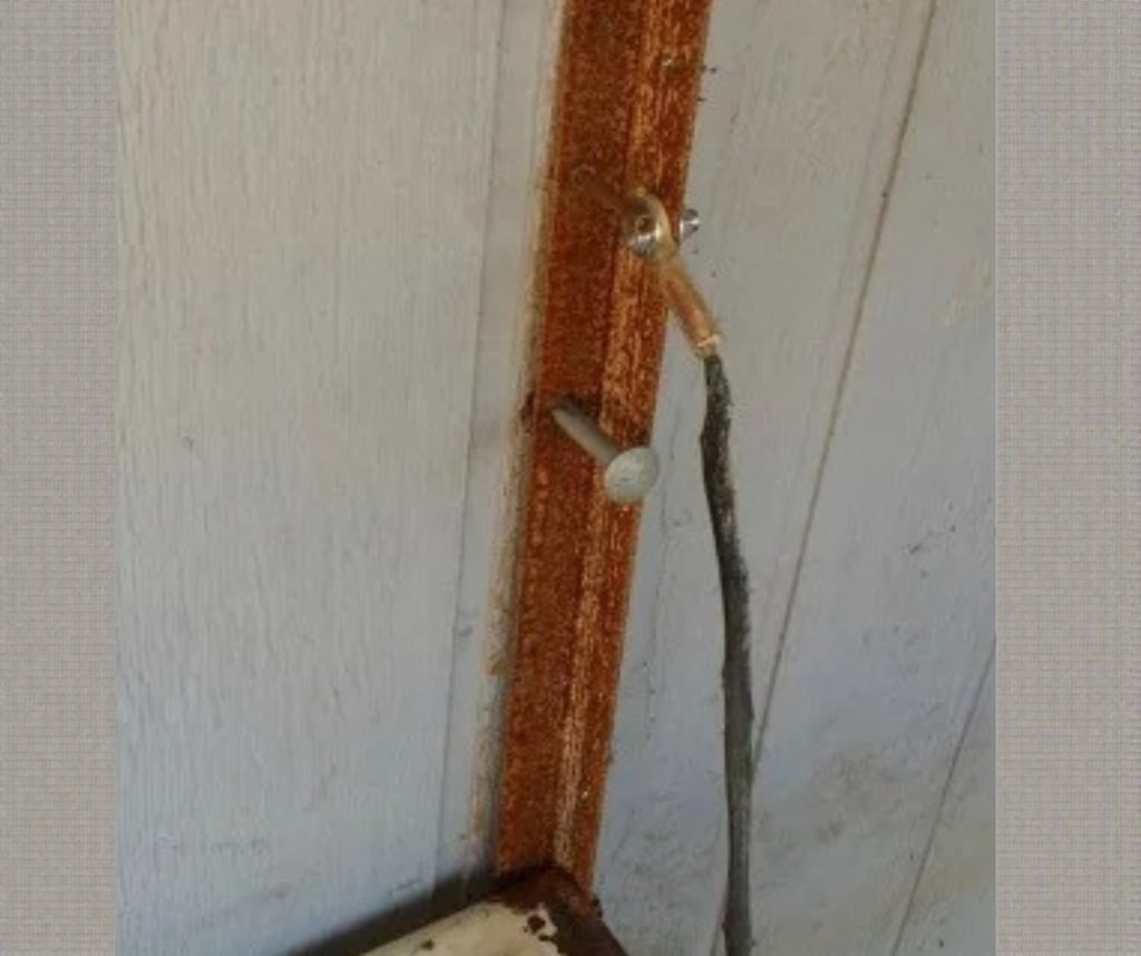 Holes drilled through angle and wall; 8" stove bolts used as through-bolts.