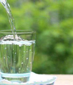 An image of distilled water being poured onto a glass.