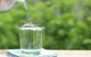 An image of distilled water being poured onto a glass.