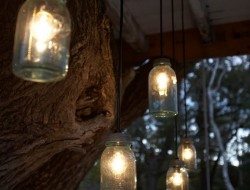 Reporposed mason jars become rustic lights hanging from underneath the treehouse.