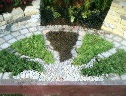 Radiating pebble sun mosaic with herbs (part of the gold awarded show garden at the 2012 Harrogate Autumn flower show) — at Harrogate Flower Show.