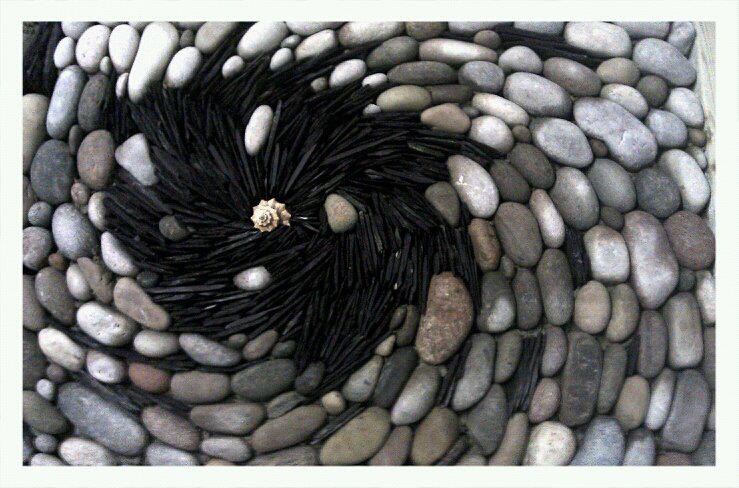 A vortex of cobbles, roof slate and a sea shell