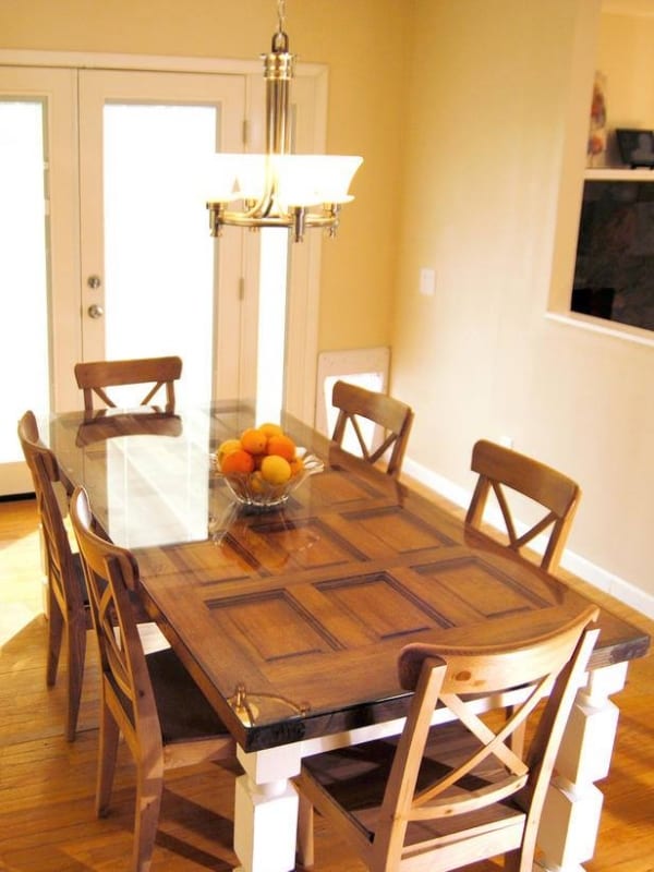 Need a dining table? All you need is an old door, table legs, and a glass to go on top of it.