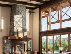 Dark timber beams flow through to the exterior above while a large stone fireplace and window-wall add character and space to the rest of the room