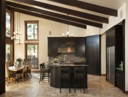 Dark wood cabinetry matches the angled timber in this kitchen