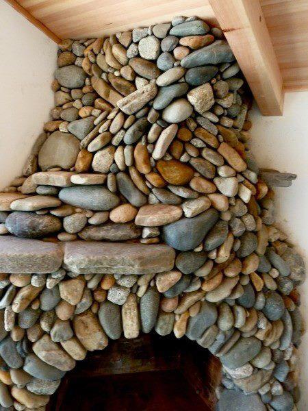 This river rock fireplace looks like it is made using the principles of a dry stone wall and with all that stone it would radiate heat long after the fire goes out.