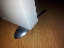 Here's an idea that uses a spoon as a door stopper.