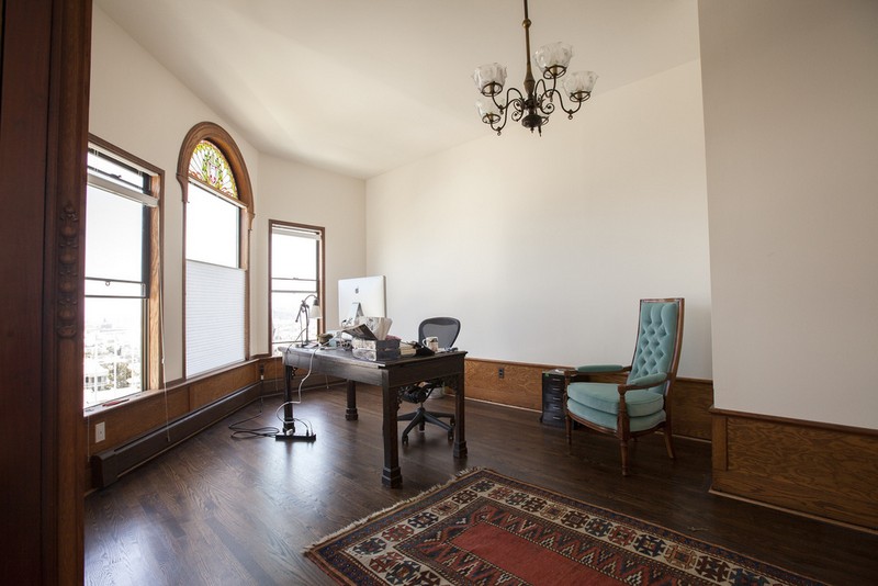 The master study off of the main room on the top master floor has beautiful views, and is freshened by the new paint and darkened floors. The original fixtures and wood paneling remain.