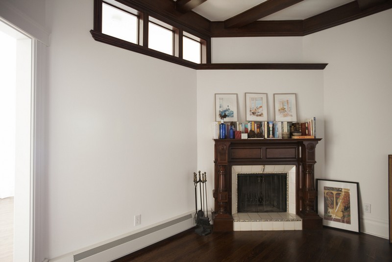 The original beams in the ceiling and the original fireplace have such beautiful rich wood, painting the walls around them a bright white accentuates their deep colors.