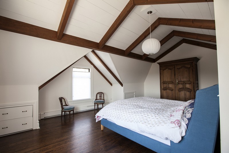 On the top floor, the master bedroom caries the style of the rest of the house with its dark stained floors, white walls and mix of modern and vintage elements.