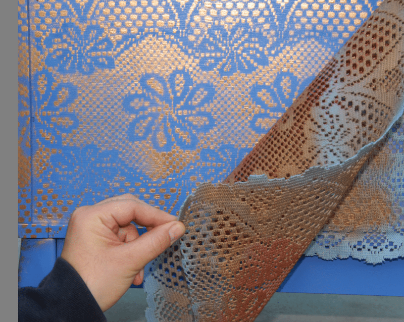 An image of a dresser with a lace effect painting.