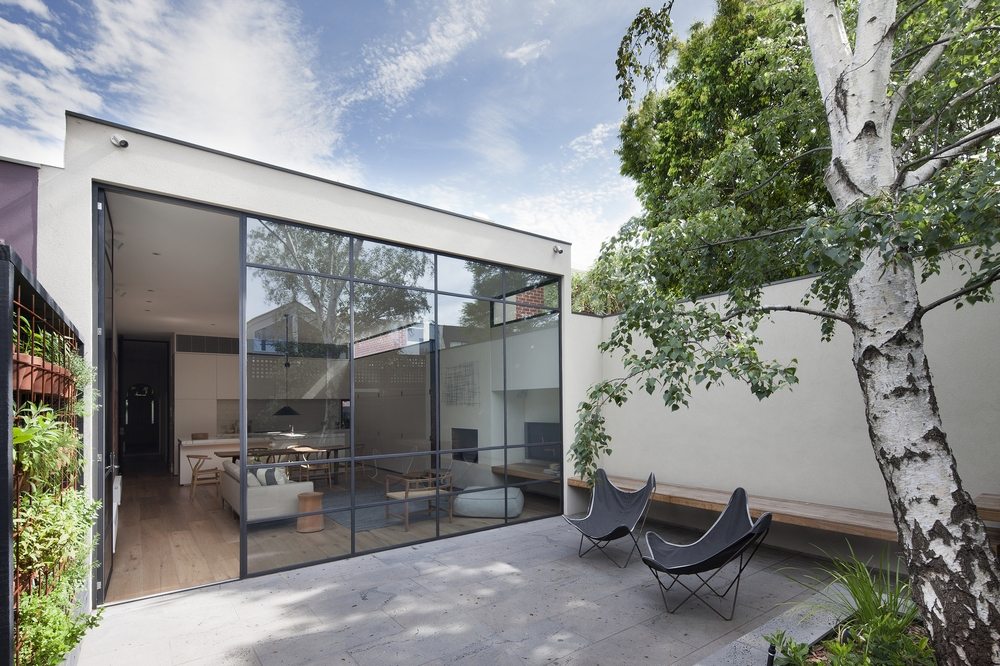 Large glass windows bring the outdoors in while bathing the home with sunlight.