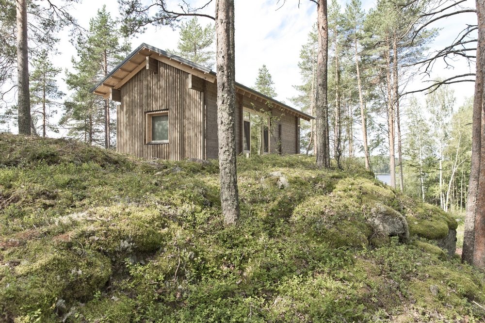 The cabin sits on top of a narrow granite ridge, surrounded by tall trees with stunning lake views.