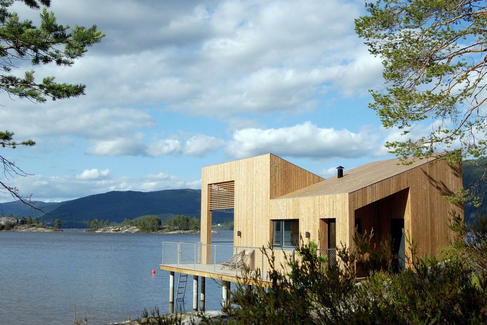 Nisser Micro Cabin stands on stilts above the water and partially on land.