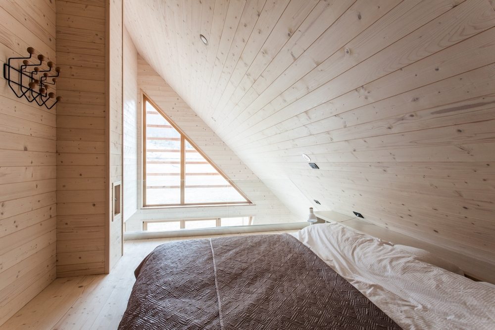 The bedroom walls follow the slanted shape of the roof.