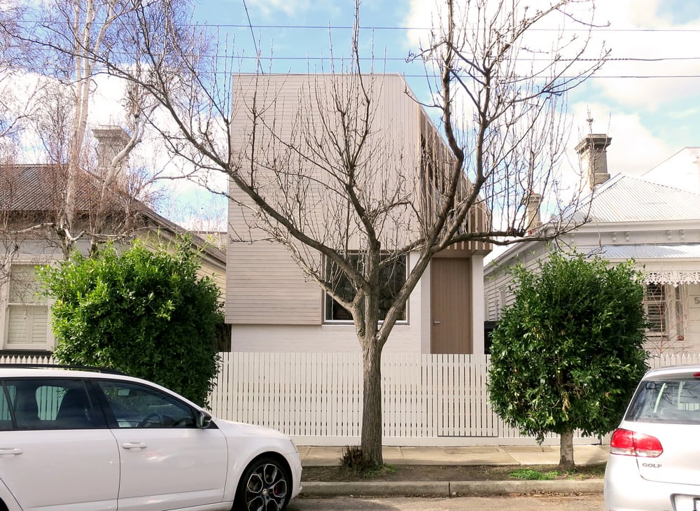 A simple, single-window facade allows the house to blend well with its neighbors.