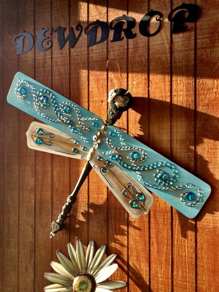 an image of a dragonfly yard art on a wall.