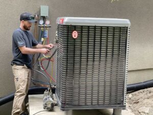 A contractor installing a heat pump onto an apartment.