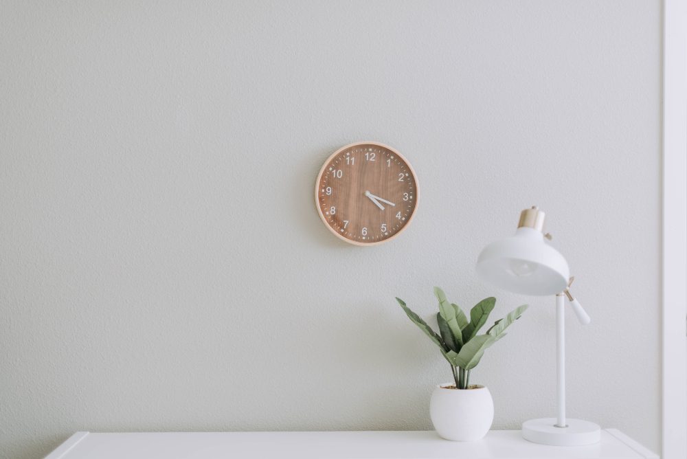 An image of a minimalist design using a clock and desk.