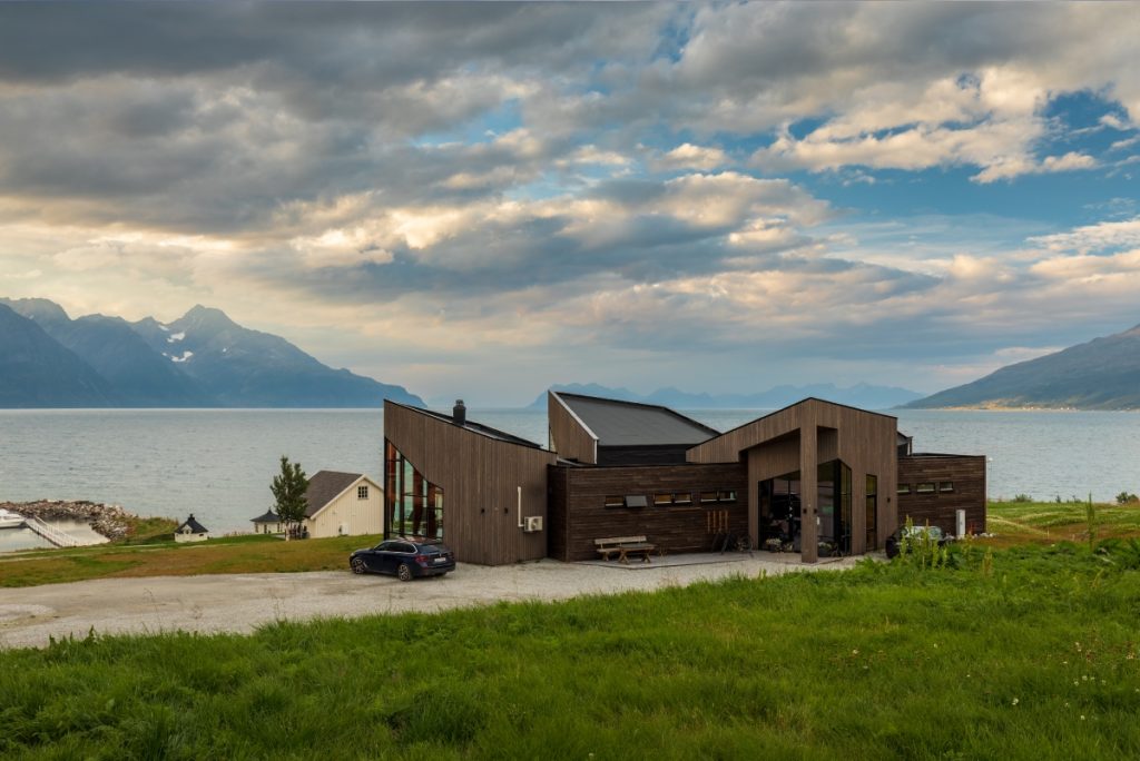 An image of a modern mountain home near a lake.