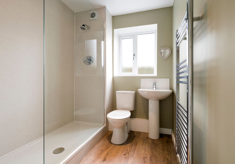 An image of a white small bathroom utilizing natural light. and neutral colors. 