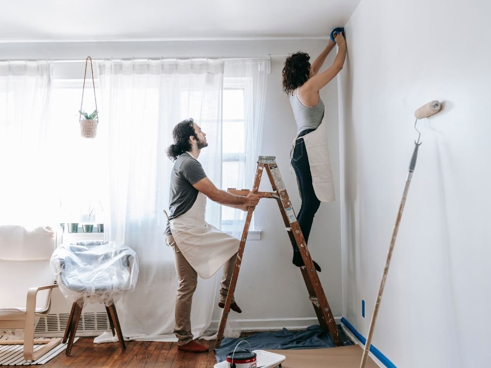 An image of a Gen Z couple working on their wall renovation. 