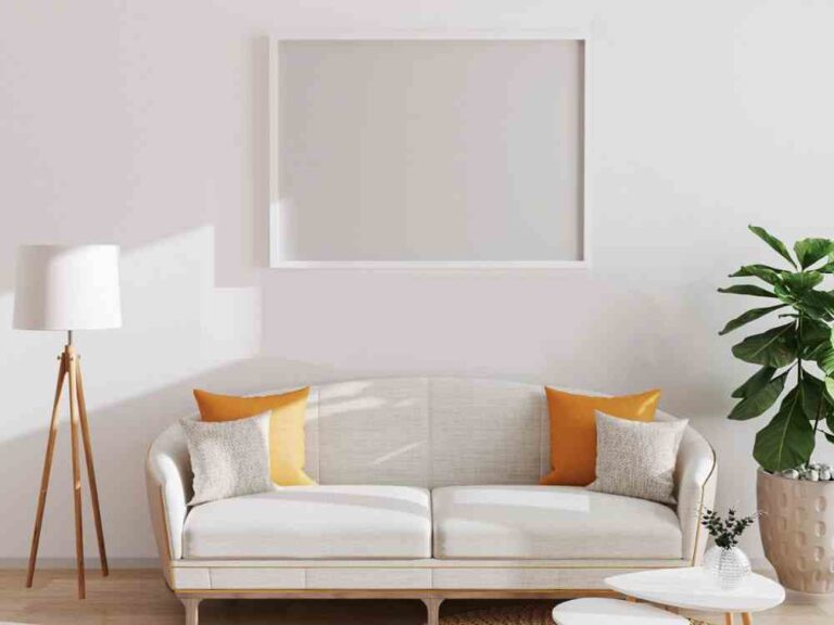 An image of an empty frame above a couch for an article about how to decorate the wall above your couch.