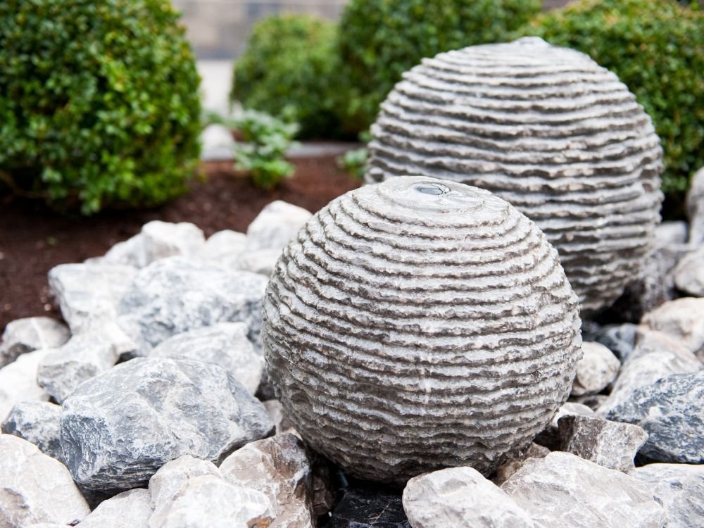 An image of a stone globe garden fountain. 