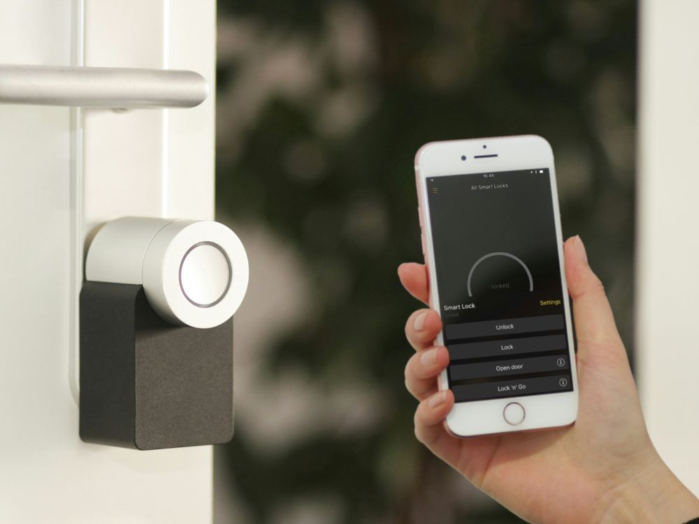 An image of a person controlling a smart lock with their phone. 