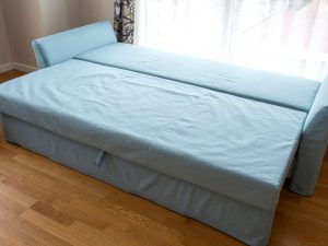 An image of a blue sofa bed in a living room.