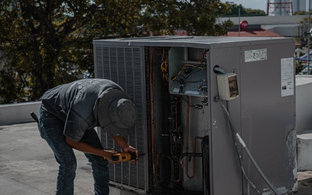 An image of a mechanic servicing a heating unit.