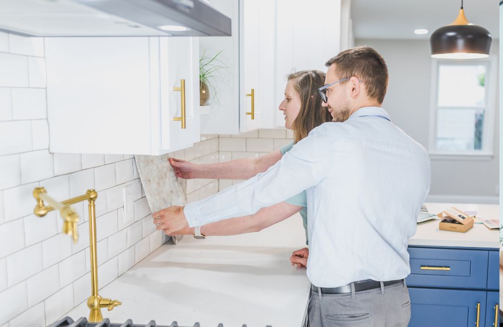 An image of a couple comparing the wall materials to the tiles.